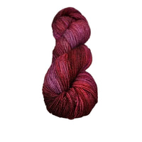 Red and purple skein of yarn on a wooden surface