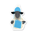 Vinyl Sticker with a sheep crocheting and wearing crocheted hat