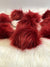 faux fur pom with strings in the color Shiraz